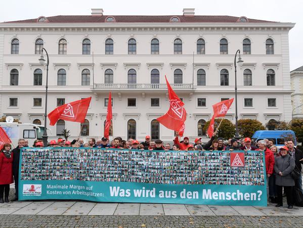Parallel zur Jahrespressekonferenz demonstrieren mehrere Dutzend Mitarbeiter vor dem Siemens Palais und breiteten ein Transparent mit Fotos von 600 Konzern-Beschäftigen aus.