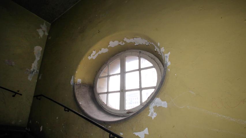 Eine dicke Staubschicht bedeckt das runde Fenster im Treppenhaus - das Licht bahnt sich nur schwer seinen Weg ins Innere.