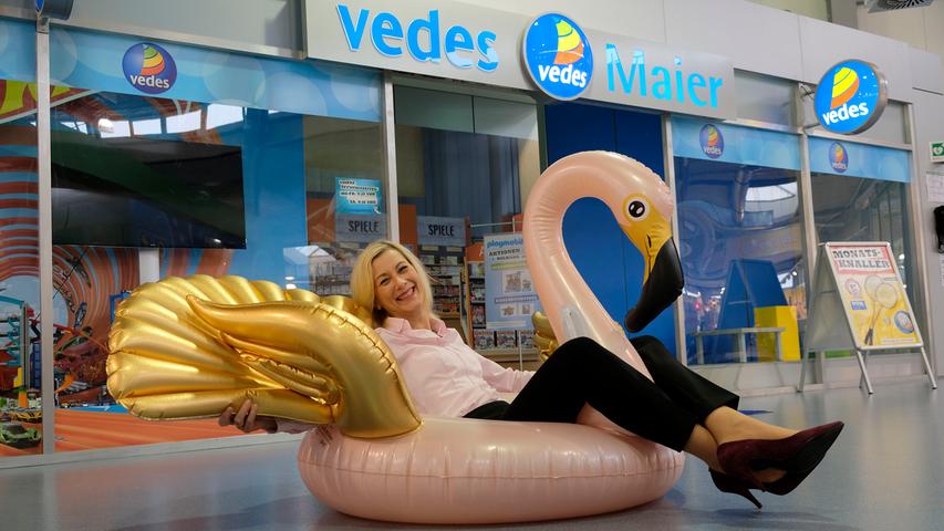 Sich stilvoll auf dem Wasser treiben lassen und dabei Luft zufächeln: Das rosa-güldene Flamingo-Schwimmtier mit passendem Riesenfächer macht's möglich. Zu haben ist es ab Frühjahr 2018 – Vedes-Pressesprecherin Eva-Maria Kusch hat schon mal Platz genommen.