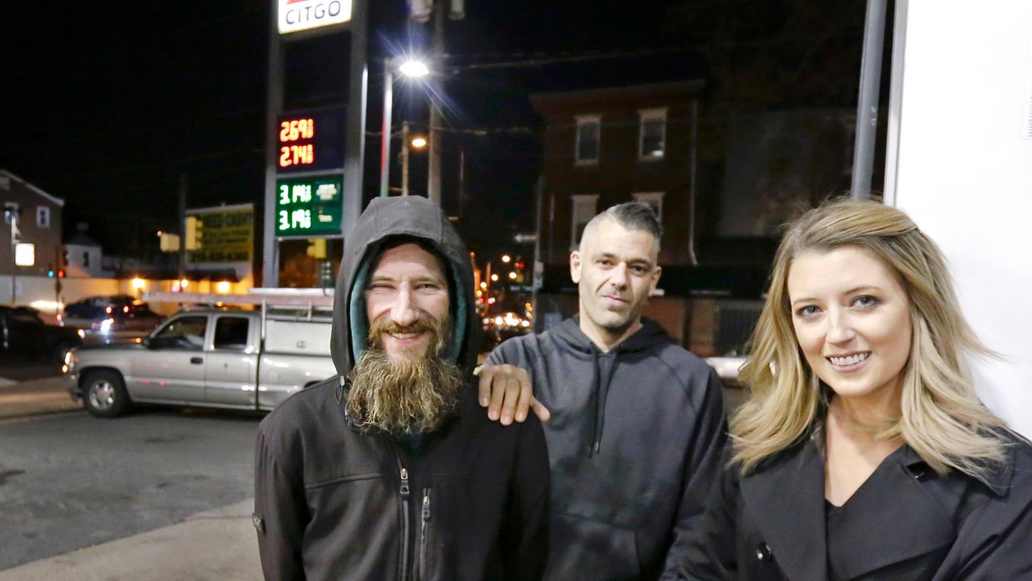 Der Obdachlose Johnny Bobbitt Jr. (links), Kate McClure und ihr Freund Mark D'Amico stehen am Citgo Stadion in Philadelphia.