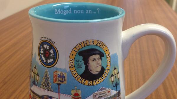 2017 war die Farbe der Tasse ein helles, deckendes Blau. In diesem Jahr zierte zur Erinnerung an das Reformationsjubiläum auch das Portrait von Luther samt Lutherrose die Tasse. Außerdem waren das Marktgeschehen, die Jahreszahl und das Christkind darauf abgebildet.