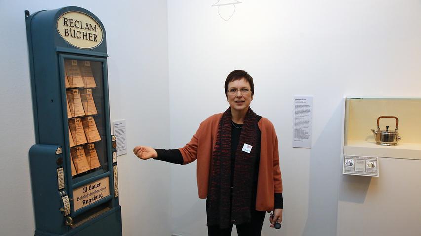 Ausstellungsleiterin Petra Krutisch mit dem Bücherautomaten von Peter Behrens.