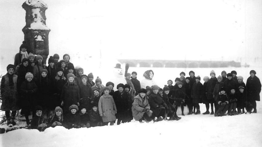Zum Kreuz im Altmühltal führte in den 1920er Jahren ein Ausflug von Gunzenhäuser Volksschülern, zusammen mit ihren Schneemännern stellten sich die Kinder zum Erinnerungsbild auf. Im Hintergrund ist die Eisenbahnbrücke über die Altmühl zu sehen.