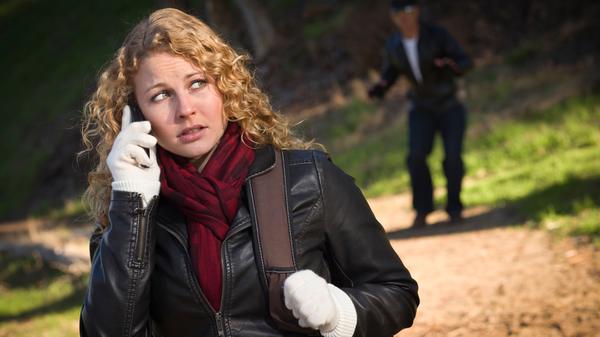 Pretty Young Teen Girl Calling on Cell Phone with Mysterious Strange Man Lurking Behind Her.