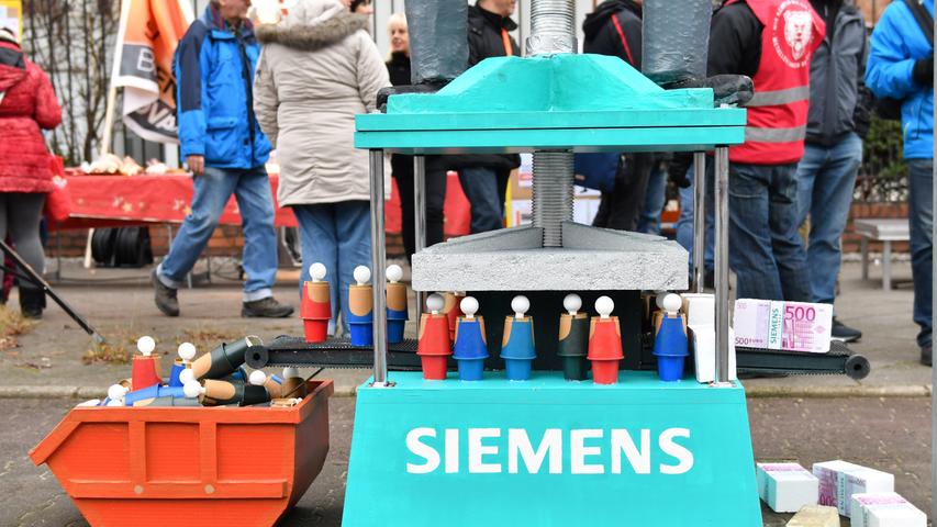 Eine übergroße Presse sollte bei einer Kundgebung von Siemens-Beschäftigten am Dynamowerk in Berlin symbolisieren, wie sich die Belegschaft fühlt.