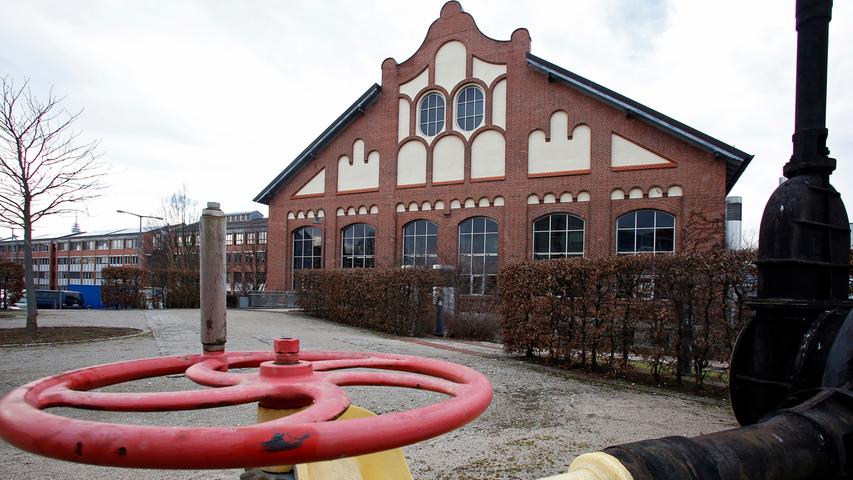 Im Vordergrund ist ein Teil eines Gasschiebers zu sehen, der einst im Inneren des Gebäudes stand. Hier wurden das erzeugte Stadtgas und der Verbrauch der Nürnberger gemessen.