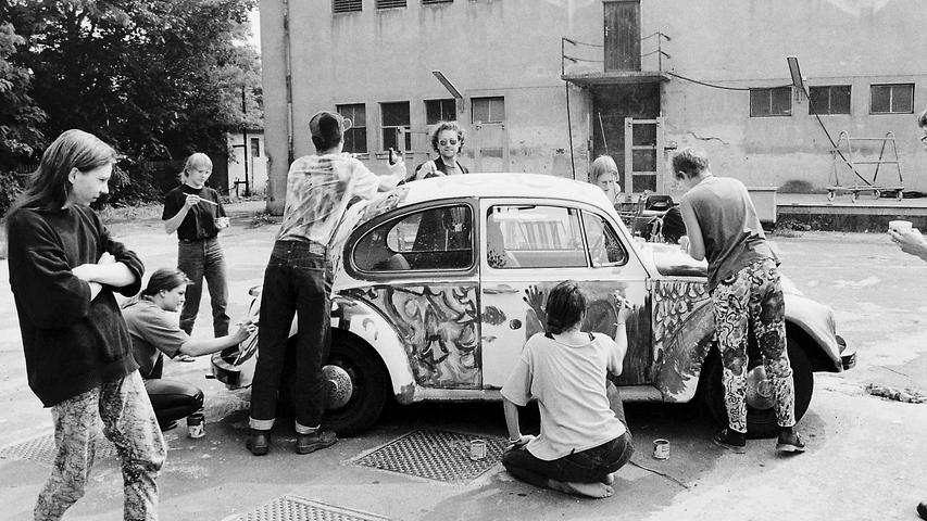 Die 1970er-Jahre waren ein buntes Jahrzehnt in Orange, Sonnengelb und Froschgrün. Ob dieses Foto aus Fürth tatsächlich in den 70ern entstanden ist, ist nicht bekannt. Und weil es ein Schwarz-Weiß-Bild ist, wissen wir leider auch nicht, welche bunten Farben die jungen Leute da auf den Lack eines alten Käfers malten. 