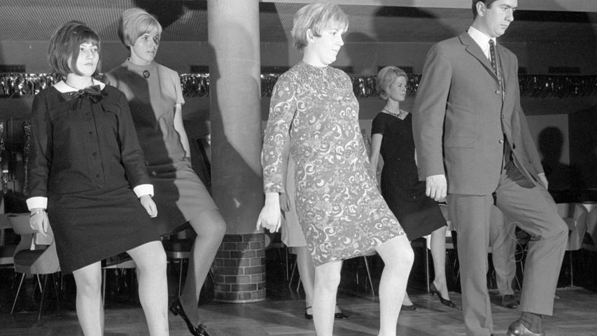 Recht lustig erscheinen den Tanzschülern die Vorübungen zum Slop. Das vorschriftsmäßig abgewinkelte Knie, die nach unten zeigenden auswärts gerichteten Fußspitzen des Lehrers (re.), lassen sich langsam ohne weiteres nachahmen.  Hier geht es zum Kalenderblatt vom 21. Januar 1968: "Faschingsschlager auf dem Parkett"