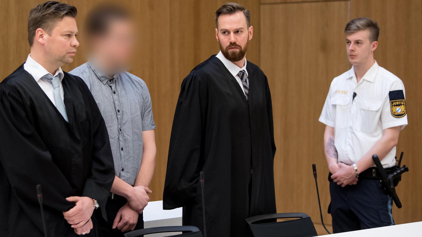 Der Angeklagte Philipp K. (2.v.l.) steht am Freitag in München zusammen mit seinen Anwälten im Verhandlungssaal. Die Staatsanwaltschaft wirft dem 33-Jährigen unter anderem fahrlässige Tötung in neun Fällen und illegalen Waffenhandel vor.