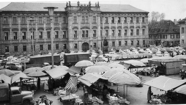 Verschiedene Sparmaßnahmen ließen den Bau der typischen Stadtresidenz karger werden als geplant: Es entstand ein langgestreckter Bau mit einem Mittelrisalit, dessen Attika sechzen Statuen umstehen. Seit 1763 Witwensitz der Markgräfin Sophie Karoline, brannte das Schloss 1814 aus. 1817 wurde es der Universität übergeben und diente dann als Bibliothek. Nun ist das Schloss das Verwaltungsgebäude der FAU, hier zu sehen auf einem Foto aus den 1960ern. Kurz nach dem Brand ist das neugebaute Krankenhaus ist im Jahr 1824 fertig. In den kommenden Jahren entstehen in Erlangen weitere Gebäude der Medizin – etwa die Anatomie und die Pathologie.