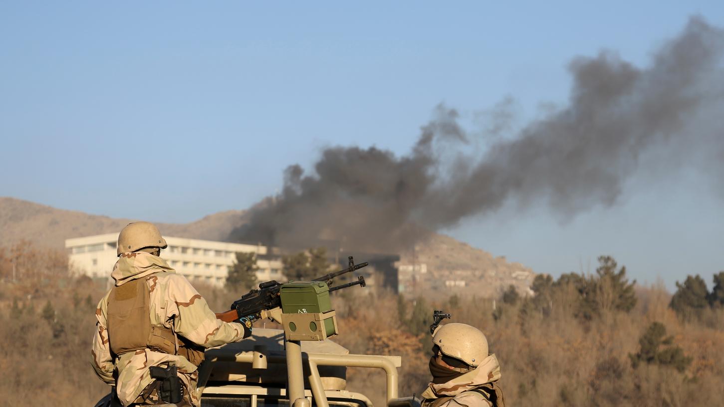 Afghanische Sicherheitskräfte stehen am 21.01.2018 in Kabul unweit des Intercontinental Hotels, aus dem Rauch aufsteigt. Dort hatten am Samstagabend Kämpfer einer Taliban-Gruppierung mehrere Dutzend Menschen getötet.