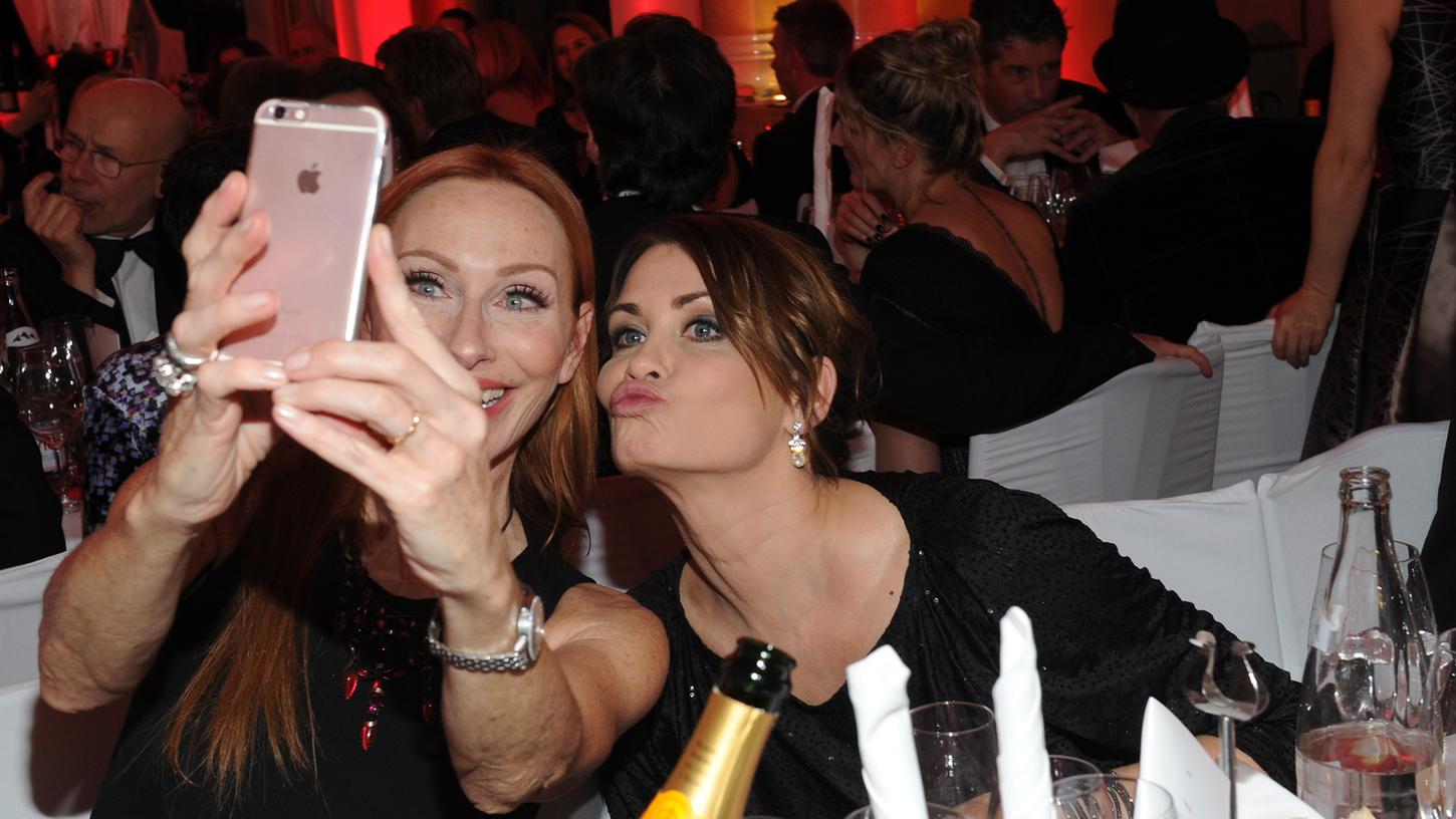 Selfie und Duckface: Diesen Moment wollten die Schauspielerinnen Andrea Sawatzki (l.) und Anja Kling wohl für die private Bildersammlung festhalten. Beim 45. Deutschen Filmball feierten die Promis ausgelassen.