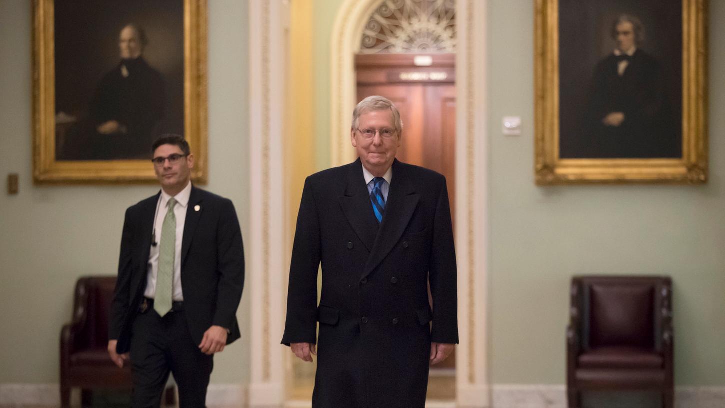 Der Mehrheitsführer der Republikaner im Senat, Mitch McConnell (mitte) ist am Sonntag in Washington auf dem Weg zu seinem Büro. Begleitet von harschen gegenseitigen Vorwürfen gehen in Washington die Verhandlungen der Parteien über ein Ende des "Shutdown" weiter.