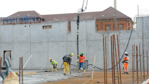...unten lassen Arbeiter gerade 200 Kubikmeter Beton einfließen.