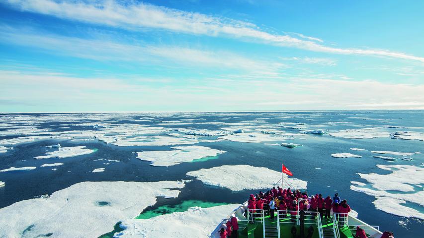 Gebannt verfolgen die Expeditionsteilnehmer, wie sich das Boot in der Arktis durchs ewige Eis bricht.