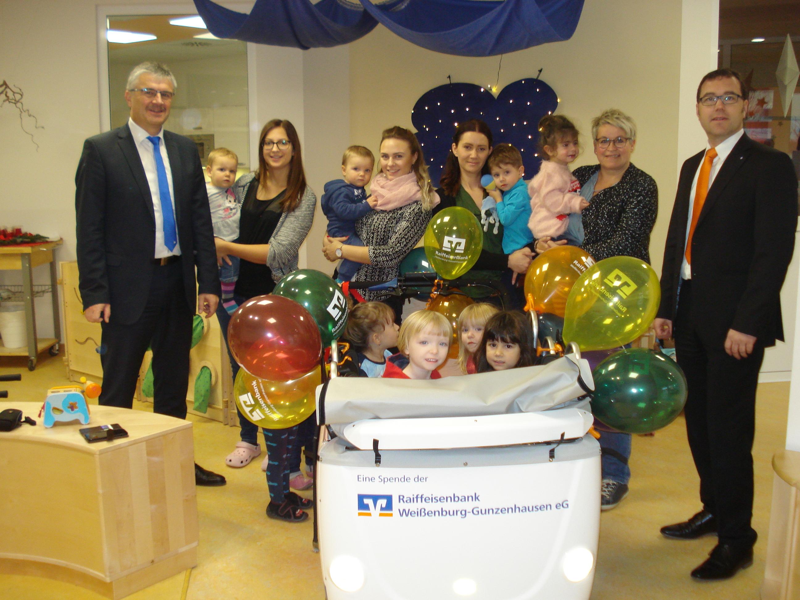 Über einen neuen „VR-mobil Kinderbus“ durfte sich das Kinderhaus „Fuchsbau“ freuen. Die Raiffeisenbank Weißenburg-Gunzenhausen stellte der integrativen Einrichtung im Rahmen der Aktion „VR-Banken machen mobil“ das moderne Fahrzeug im Wert von 5000 Euro zur Verfügung. Mit sechs Sitzen, Sicherheitsgurten, einer Gepäckablage und einem Verdeck ist der Kinderbus perfekt ausgestattet und ermöglicht auch Spaziergänge und Ausflüge an der frischen Luft mit den Jüngsten. Die Kompaktheit des Gefährtes unterstützt auch die Erzieherinnen, einen Überblick über ihre Schützlinge zu behalten. Der integrierte Elektromotor sorgt für „Rückenwind“ und beugt so Überlastungen vor. Übergeben wurde das Fahrzeug von Geschäftsstellenleiter Stefan Biber (links) und seinem Stellvertreter Michael Uhlig (rechts) . Groß war die Freunde natürlich auch bei den Erzieherinnen und Kindern, die gleich in ihrem neuen Gefährt Probe saßen.