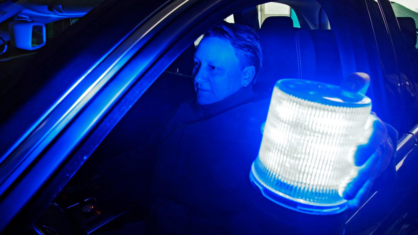 Dank eines starken Magneten können die Polizisten (wie hier Barbara Brechtelsbauer) das Blaulicht auch bei Tempo 160 noch ohne Probleme aufs Autodach setzen.