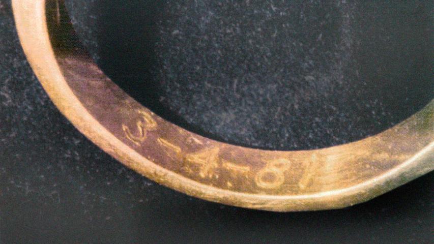 Frau und Mann trugen am linken Ringfinger Eheringe aus Gold. Die Gravur steht für das Hochzeitsdatum.