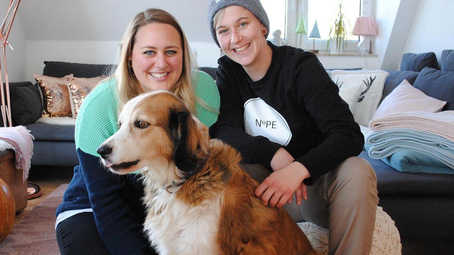 Lisa Nicklas (li.) und Julia Felßner, hier mit Hund Sammy in ihrer vor kurzem bezogenen Wohnung in Schwabach, wollen sich die Hochzeit nicht verbieten lassen. Auch wenn das bedeutet, dass sich Lisa einen neuen Job suchen muss.