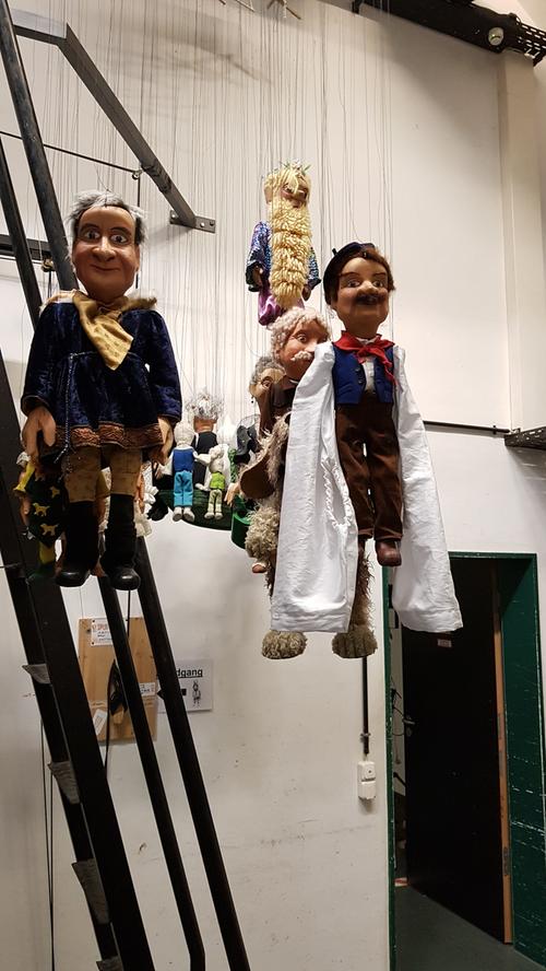 Ein Blick hinter die Kulissen: An langen Fäden hängen die Marionetten für die abendliche Kabarettvorstellung bereit. 16 Puppenspieler sind bei der Augsburger Puppenkiste beschäftigt und teilen sich den Platz auf den hohen Brücken hinter der Bühne.