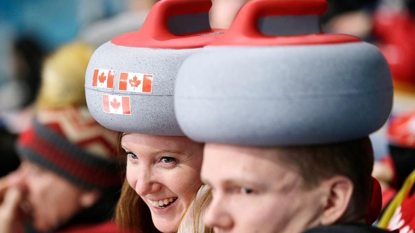 Auch diese Curling-Fans zeigen sich von ihrer kreativen Seite: Zwei Zuschauer des kanadischen Teams tragen Curling-Steine auf dem Kopf und werden damit zu einem echten Hingucker am Spielfeldrand.