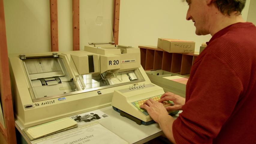 Lochkarten, wie Edwin Aures vom Regionalen Rechenzentrum (RRZE) sie zeigt, waren noch bis in die 1980er Jahre hinein das Programmiermedium der Wahl.