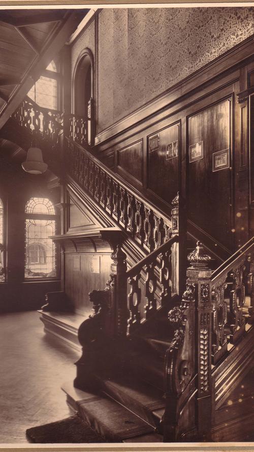 Das Foto des ursprünglichen Vestibüls der Villa dokumentiert die opulente Ausstattung mit Holzvertäfelung und Glasgemälden in den Fenstern.