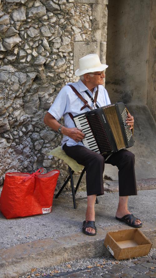Ein Straßenmusiker verdient sich im Schatten der Kathedrale von Avignon ein paar Euro.