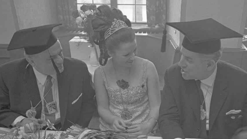 Zwar lächelnd aber doch wehmütig sitzt Prinzessin Gerlinde I. zwischen dem OB und seinem "Vize", die sich mit ihren Doktorhüten zeigen. Hier geht es zum Kalenderblatt vom 28. Februar 1968: Kehraus von der Sonne vergoldet