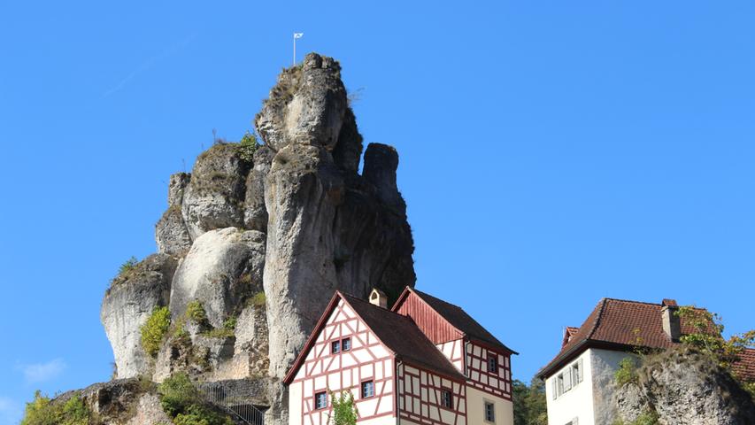 Tüchersfeld, das Felsendorf. Der Fahnenstein daneben ist ein beliebter Aussichtspunkt der Gäste. Durch einen kleinen Felsdurchbruch gelangt man zur Aussichtsplattform. Oben angekommen, hat man einen atemberaubenden Blick hinunter auf den kleinen Ort sowie auf das Fränkische Schweiz-Museum.