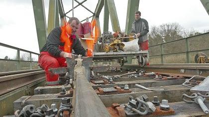 Ungewohnt ruhig war es vor Ostern für die Anlieger der Rangaubahn. Seit Montag, 29. März, ruhte der Zugverkehr. Grund dafür waren dringende Reparaturarbeiten an der Strecke. Zu den wichtigsten Maßnahmen gehörte das Erneuern der Gleise auf der Bahnbrücke über den Main-Donau-Kanal zwischen Dambach und Alter Veste. Morsche Holzbohlen wurden ausgewechselt, neue Schienen darauf befestigt. Kleine Feuerwerke gab es beim Verschweißen der Gleissegmente. Mit Flammenwerfern wurden die Schienen zunächst erhitzt, damit sie sich ausdehnen und die Stoßfugen schließen. Anschließend wurde eine mit Sand gefüllte Form über die Fuge gestülpt und mit flüssigem Stahl gefüllt. Die Bahnfahrgäste mussten mit Bussen vorliebnehmen und mit Verspätungen rechnen. Ab Karfreitag verkehren die Züge wieder. Behinderungen gibt es bis einschließlich Ostermontag noch auf der Neustädter Bahnlinie. Wegen einer Weichenreparatur werden ab Siegelsdorf Busse eingesetzt. Längere Fahrzeiten sind die Folge. Ungewohnt ruhig war es vor Ostern für die Anlieger der Rangaubahn. Seit Montag, 29. März, ruhte der Zugverkehr. Grund dafür waren dringende Reparaturarbeiten an der Strecke. Zu den wichtigsten Maßnahmen gehörte das Erneuern der Gleise auf der Bahnbrücke über den Main-Donau-Kanal zwischen Dambach und Alter Veste. Morsche Holzbohlen wurden ausgewechselt, neue Schienen darauf befestigt. Kleine Feuerwerke gab es beim Verschweißen der Gleissegmente. Mit Flammenwerfern wurden die Schienen zunächst erhitzt, damit sie sich ausdehnen und die Stoßfugen schließen. Anschließend wurde eine mit Sand gefüllte Form über die Fuge gestülpt und mit flüssigem Stahl gefüllt. Die Bahnfahrgäste mussten mit Bussen vorliebnehmen und mit Verspätungen rechnen. Ab Karfreitag verkehren die Züge wieder. Behinderungen gibt es bis einschließlich Ostermontag noch auf der Neustädter Bahnlinie. Wegen einer Weichenreparatur werden ab Siegelsdorf Busse eingesetzt. Längere Fahrzeiten sind die Folge.