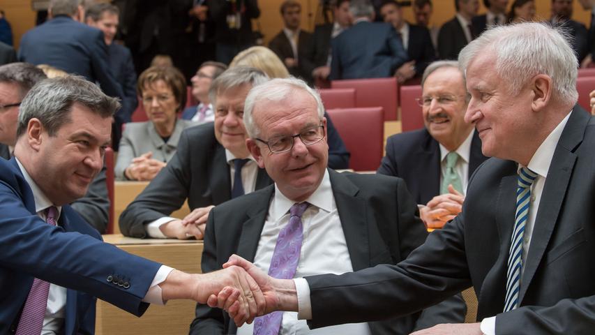 Es folgt ein Handschlag: Horst Seehofer gratuliert Markus Söder zum eindeutigen Wahlergebnis. Der CSU-Fraktionsvorsitzende Thomas Kreuzer schaut den beiden dabei tief in die Augen.