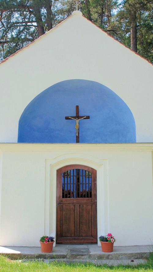 Die sogenannte Binsenkapelle am Waldrand des Elbersrother Holzes, an der Straße von Schönau nach Sickersdorf (einem zur Stadt Herrieden gehörenden Weiler), zeichnet sich durch seine ungewöhnliche Form aus. Das religiöse Kleindenkmal setzt sich aus einer halbrunden Apsis mit einer niedrigeren Mauer davor zusammen. Da die Apsis durch die nur halb so hohe Kapellenmauer offen bleibt, ist das Holzkreuz innerhalb der Kapelle immer sichtbar. Diese Mischform aus Kleinkapelle und Wegkreuz verleiht dem vermutlich zum Ende 18. Jahrhunderts entstandenen Flurdenkmal seine unverwechselbare Charakteristik. Der verputze Ziegelbau ist ansonsten schlicht gestaltet und nur durch wenige architektonische Elemente gegliedert. Die sogenannte Binsenkapelle am Waldrand des Elbersrother Holzes, an der Straße von Schönau nach Sickersdorf (einem zur Stadt Herrieden gehörenden Weiler), zeichnet sich durch seine ungewöhnliche Form aus. Das religiöse Kleindenkmal setzt sich aus einer halbrunden Apsis mit einer niedrigeren Mauer davor zusammen. Da die Apsis durch die nur halb so hohe Kapellenmauer offen bleibt, ist das Holzkreuz innerhalb der Kapelle immer sichtbar. Diese Mischform aus Kleinkapelle und Wegkreuz verleiht dem vermutlich zum Ende 18. Jahrhunderts entstandenen Flurdenkmal seine unverwechselbare Charakteristik. Der verputze Ziegelbau ist ansonsten schlicht gestaltet und nur durch wenige architektonische Elemente gegliedert.