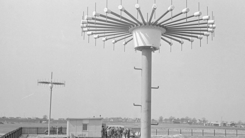 Zwei Peilantennen für verschiedene Frequenzbereiche fallen den Spaziergängern an der Südwestecke des Flughafens auf. In dem "Topf" auf dem Mast tastet ein schnelllaufendes "Goniometer" die Funksignale ab und macht sie auf einem kompassähnlichen Anzeigegerät im Kontrollturm sichtbar. Der Flugsicherungslotse (re) erkennt jederzeit den Standort des FLugzeugs, mit dem er gerade spricht. Hier geht es zum Kalenderblatt vom 31. März 1968: Luftsprung nach London