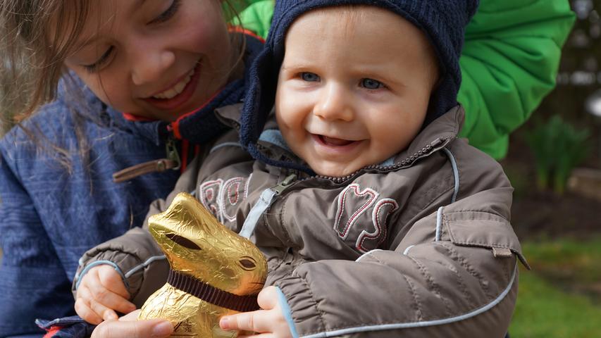 Sein ersters Osterfest: Glücklich hält der kleine Maximilian, hier auf dem Arm seiner Großcousine, den Schoko-Osterhasen fest.