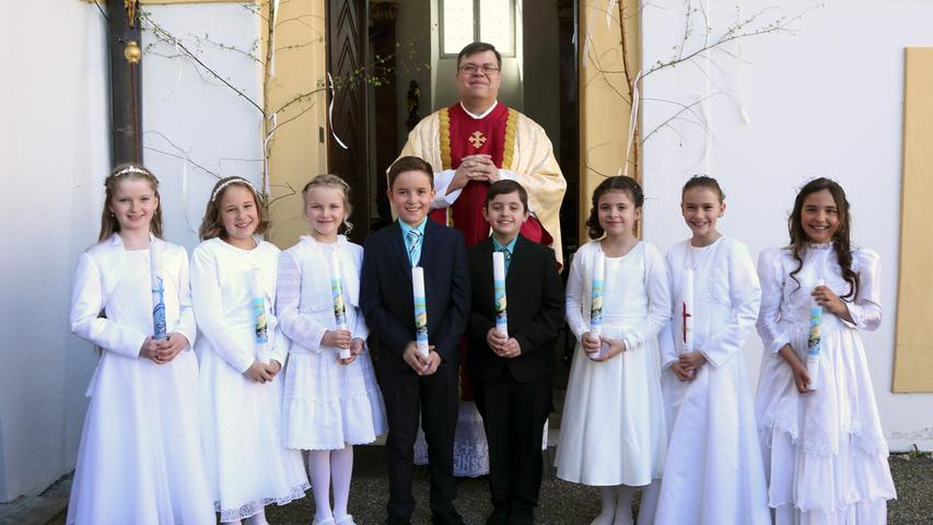 Pfarrer Gerhard Grössl mit den Absberger Kommunionkindern am Eingang des Gotteshauses.
