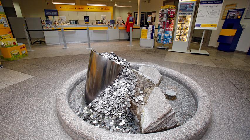 Blickfang in der Schalterhalle der heutigen Postbank ist ein Dukatenbrunnen, den der Würzburger Künstler Rainer Krämer-Guille geschaffen hat.
