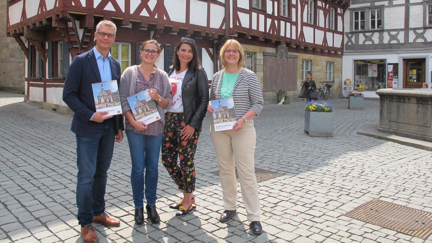 Oberbürgermeister Uwe Kirschstein, Edith Käppner und Monika Heid von der inixmedia Bayern GmbH Bamberg sowie Britta Kurth, Pressesprecherin der Stadt (von links), halten die frisch gedruckte Broschüre in den Händen.
