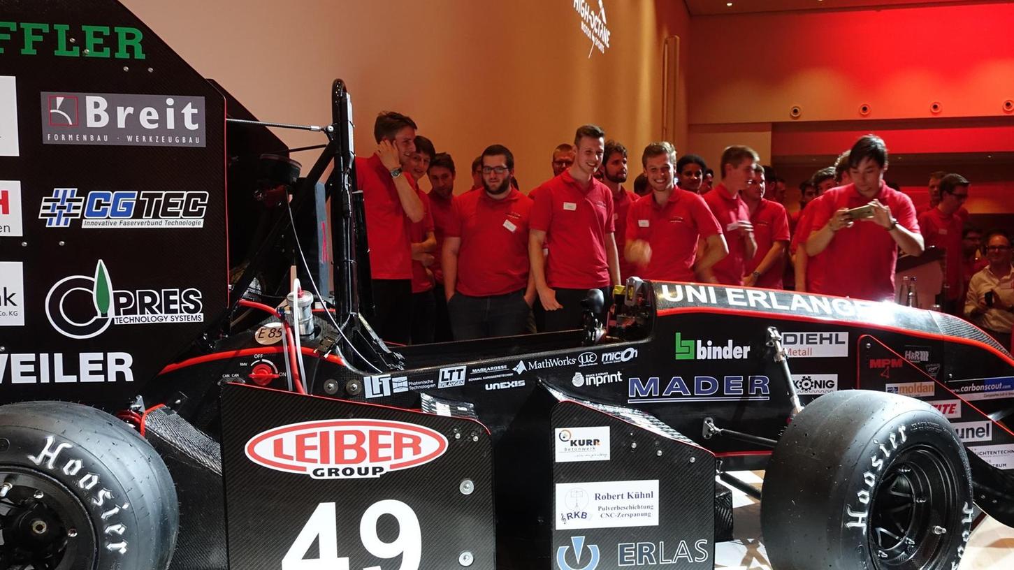 Das Formula-Team 2017/18 „High Octane“ der TechFak der Uni Erlangen (in roten Shirts) mit dem von den Studenten konstruierten und gebauten Rennwagen, der seine Qualität im internationalen Wettstreit zeigen muss. Foto: Edith Kern-Miereisz