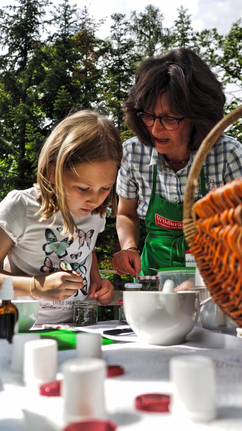 Naturführerin Elisabeth zeigt in Schenna den Kindern, wie man aus Kräutern, Harzen und Ölen Salben, Zahnputzpulver und Lippenpflegestifte macht.