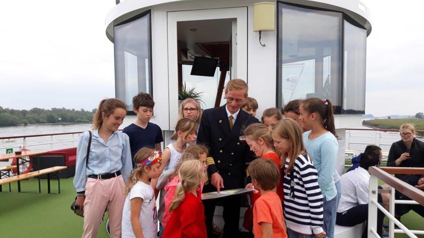 Eine Schiffsralley mit Kinderbetreuerin Judith (links)ist ein Höhepunkt im Kids Club. Kapitän Ulli Schwalbe erklärt den Kindern nicht nur Seekarten, sondern zeigt ihnen auch seinen Arbeitsplatz auf Deck.