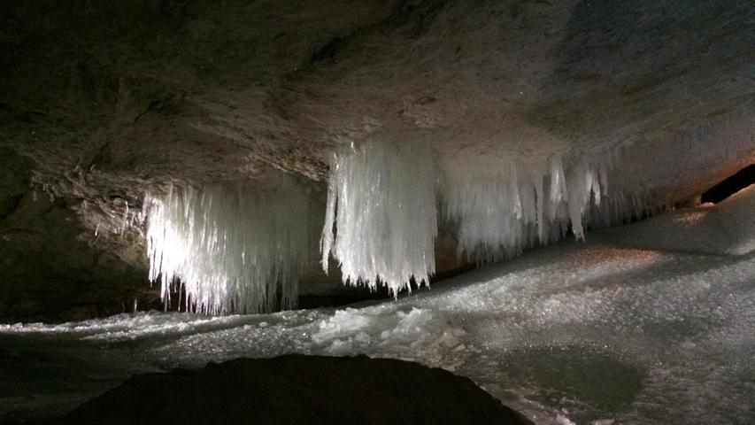 Sickerwasser, das im Inneren der Höhle gefriert, lässt Büschel an Eiszapfen wachsen.