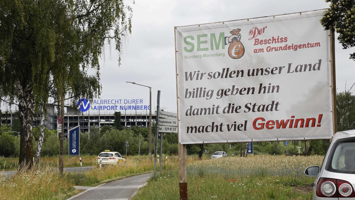 Auf Transparenten wird am Rand der Flughafenstraße gegen die „SEM“ am Marienberg protestiert.