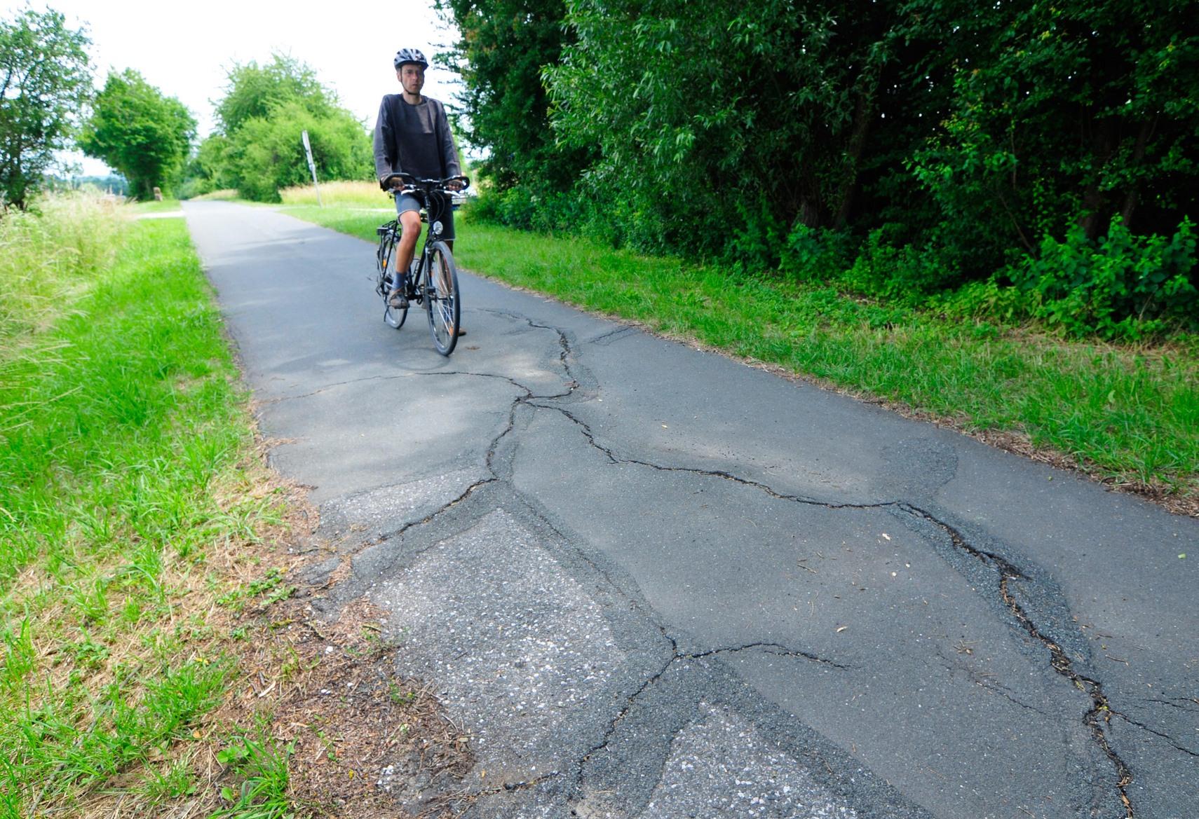 Achim Flurer und die Ritzen des Anstoßes: Auf dem Radweg von Neunkirchen am Brand nach Kleinsendelbach und umgekehrt sorgen Baumwurzeln und Frostschäden immer wieder für Beanstandungen der Nutzer.