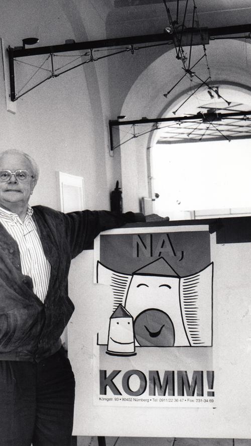Hermann Glaser Mitte der 90er Jahre neben einem Plakat: 'Na KOMM!...',