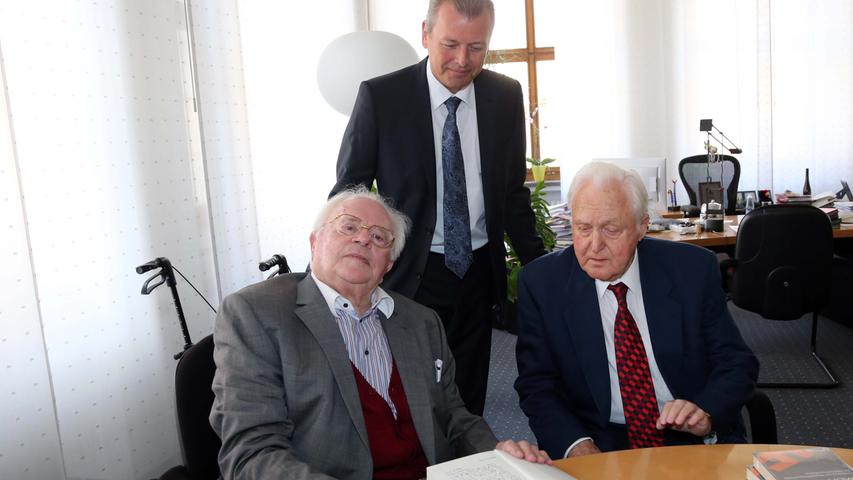 Hermann Glaser (links) übergibt sein Buch über die Hetzschrift "Mein Kampf" von Hitler an Bürgermeister Ulrich Maly (Mitte) und Ehrenbürger Oscar Schneider.