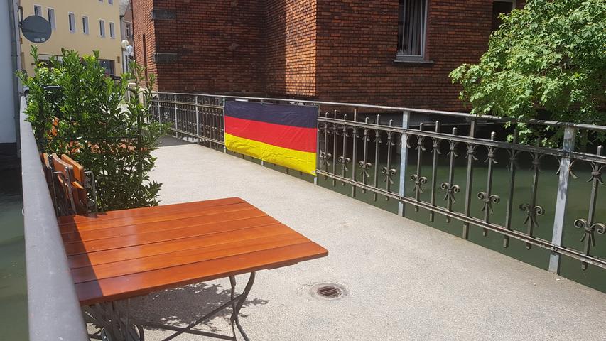 Auf der kleinen Wiesent-Brücke zwischen Hornschuchallee und Wiesentstraße hängt eine Flagge in Schwarzrotgold.