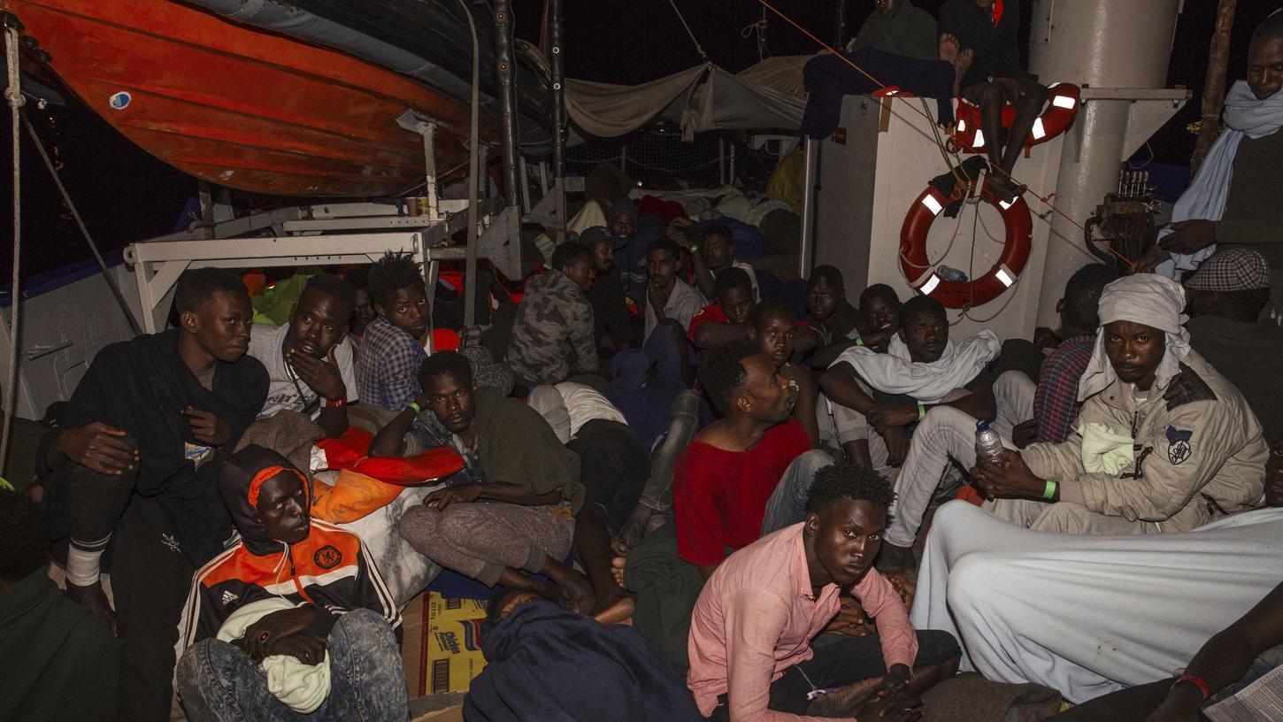 Gerettete Flüchtlinge sitzen an Bord der "Lifeline". Nach tagelangem Ausharren auf hoher See darf das Rettungsschiff nun in Malta einlaufen.