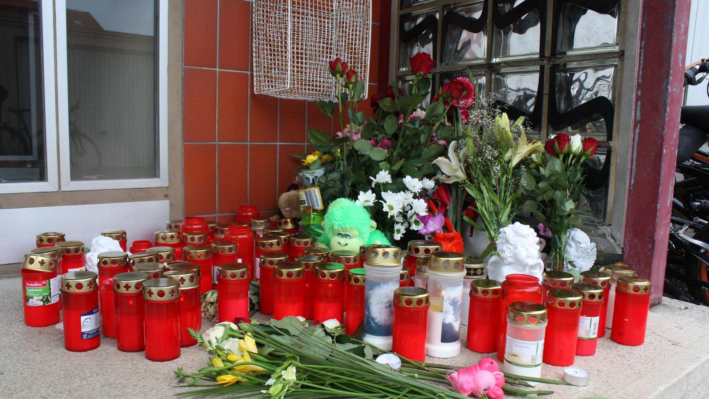 Vor dem Hauseingang haben Trauernde Kerzen, Blumen und persönliche Nachrichten abgelegt. Der beschuldigte Vater schweigt bislang zu den Vorwürfen.