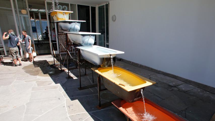 Die mächtige, durch sechs Badewannen plätschernde Wasserkaskade von Philipp Selig, David Grimm und Jonas Johnke, sorgt für erfrischende Abkühlung - und ist eine der wenigen markanten Außenarbeiten auf dem Campus.